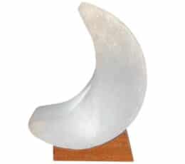 Lámpara de sal con forma de luna creciente sobre base de madera